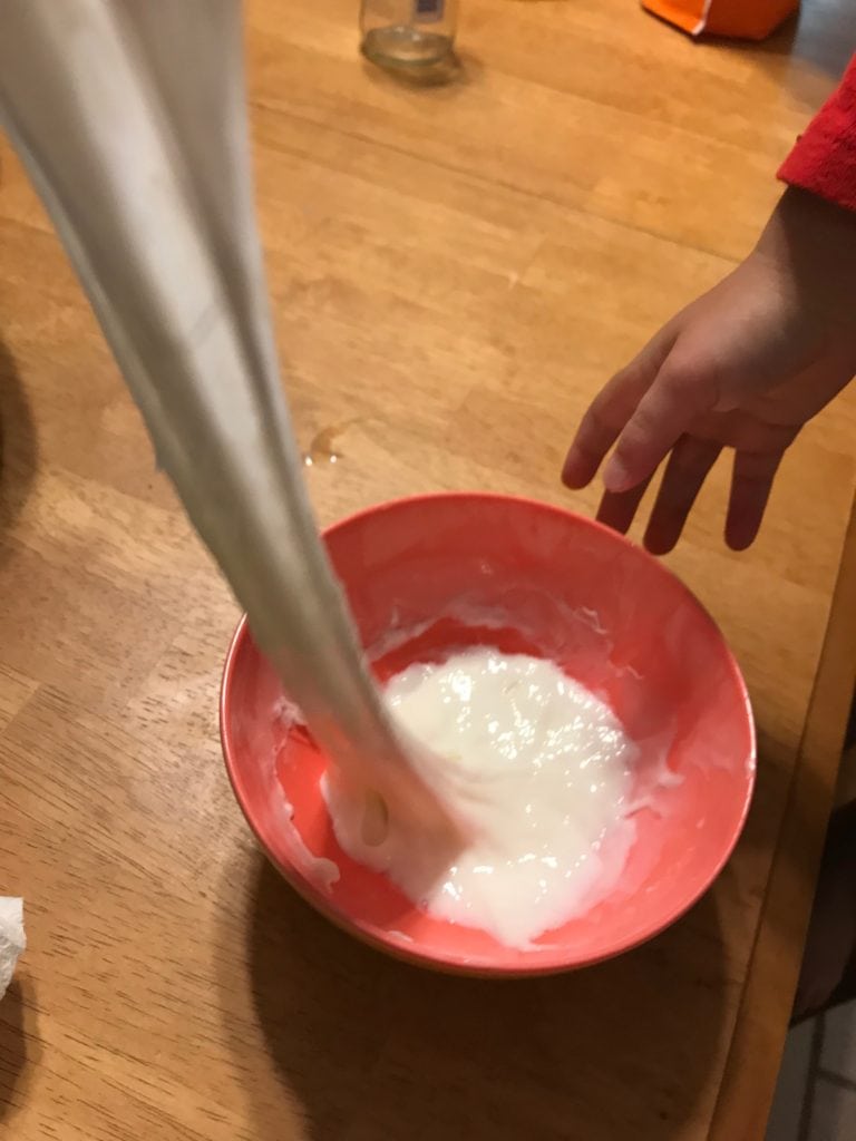 White slime being stretched from bowl
