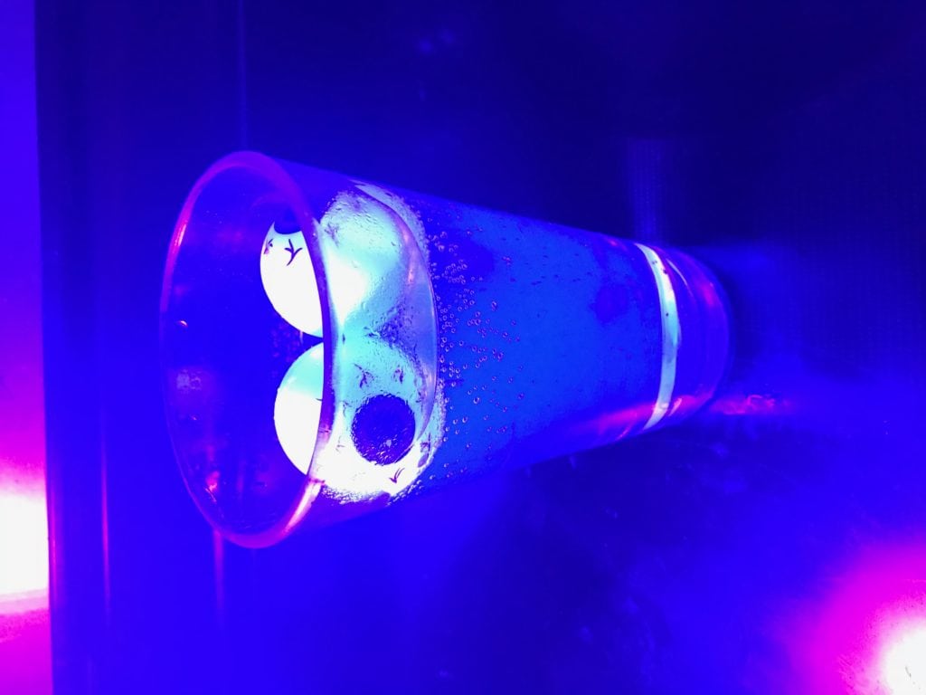 tonic water with plastic eye balls glowing under black light
