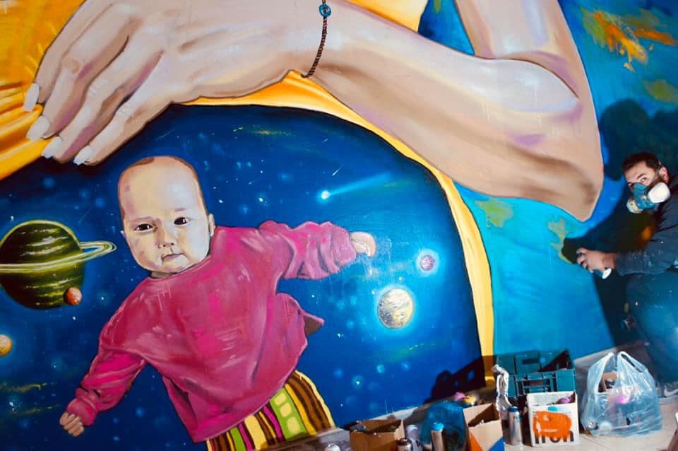 mural of baby in space womb